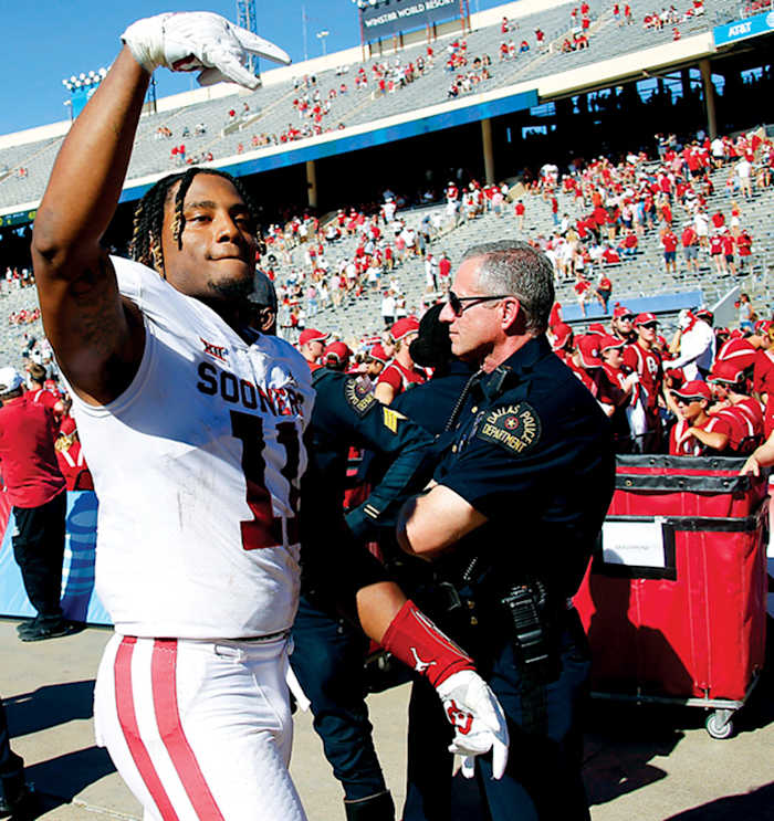 Nik Bonitto (11) gives the Horns Down gesture after OU's 55-48 win against Texas on Oct. 9 at the Cotton Bowl in Dallas.